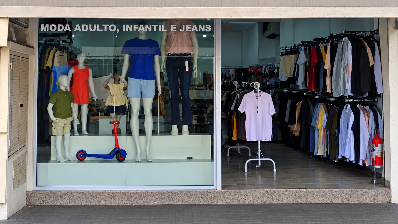 Vitrine da loja Ciaramellos com manequins de moda adulta e infantil e entrada da loja